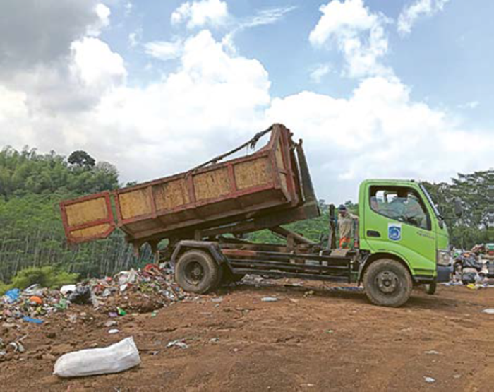 KURANG MAKSIMAL: Truk  pengangkut sampah menurunkan sampah di TPA Talangagung, Kepanjen, Kabupaten Malang, kemarin.