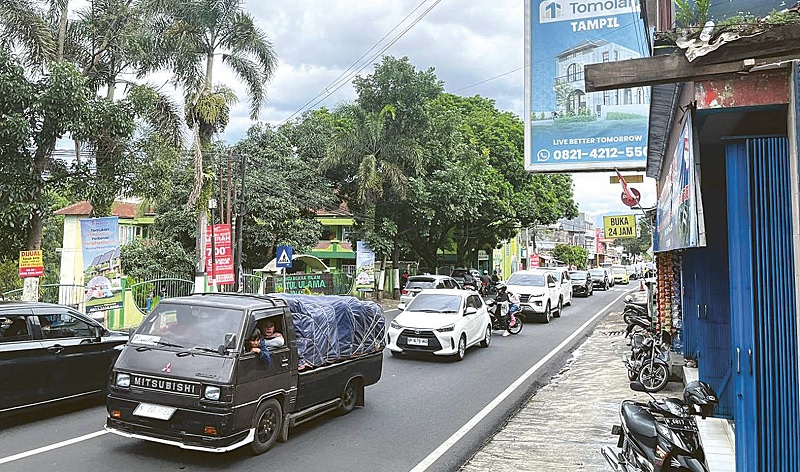 RAMAI LANCAR: Arus kendaraan di Jalan Raya Kepuharjo, Kecamatan Karangploso, masih padat kemarin. Kepadatan didominasi kendaraan roda empat dari arah Karangploso menuju