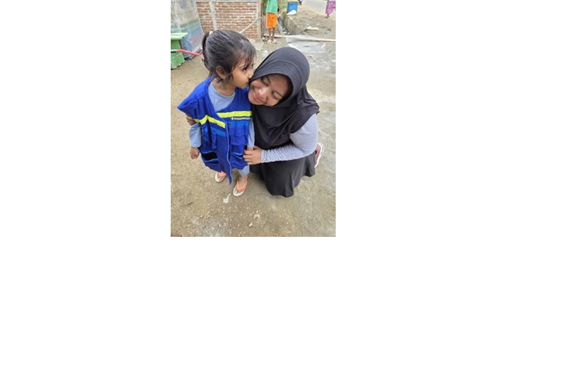 MENGABDI: Ranny Fitria Puspitasari memeluk anak yang terdampak bencana di Aceh Utara.