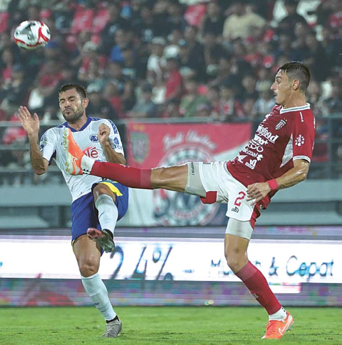 HARUS BERBENAH: Winger Arema FC Ian Puleio (kiri) berebut bola dengan pemain Bali United di Stadion Kapten I Wayan Dipta, Bali, pada Minggu lalu (4/1).
