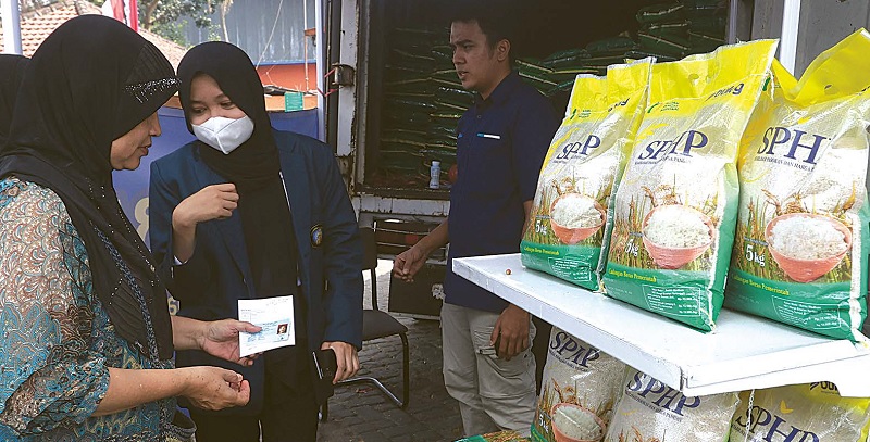 MAKSIMALKAN PENYALURAN BERAS: Seorang warga membeli beras SPHP di depan Gudang Bulog, Pakisaji, Kabupaten Malang.