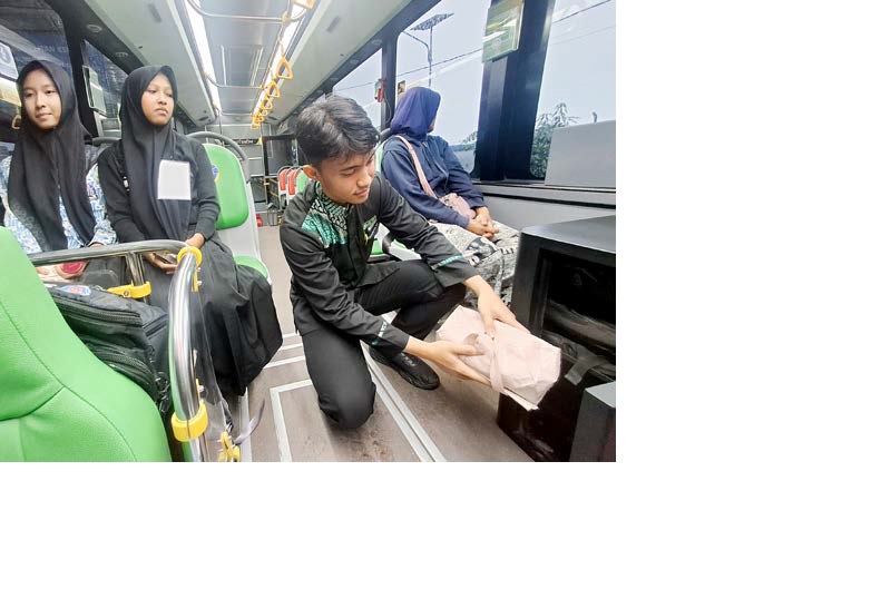 FASILITAS TAMBAHAN: Petugas Bus Trans Jatim memasukkan barang milik penumpang ke kotak yang nantinya digunakan untuk jasa ekspedisi.