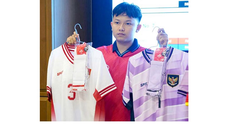 TELATEN: Rizky Surya Dimansyah menunjukkan set jersey pemain dan penjaga gawang yang akan digunakan Timnas Futsal U-16 di AFF 2025.