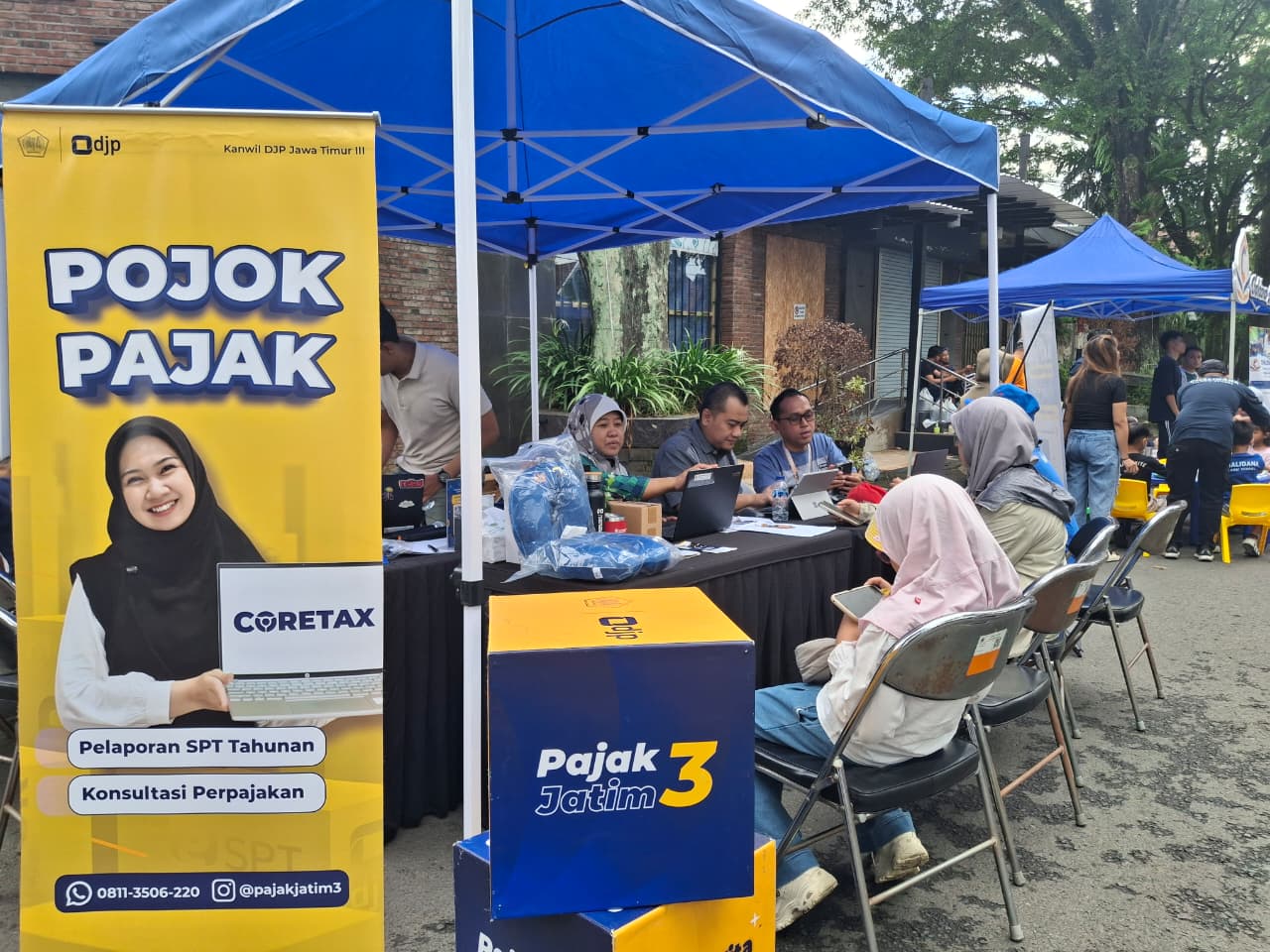 Petugas Kanwil DJP Jawa Timur III melayani aktivasi Coretax dan konsultasi perpajakan di Pojok Pajak saat Car Free Day Ijen, Minggu (11/1). (Nabila Amelia/Radar Malang)