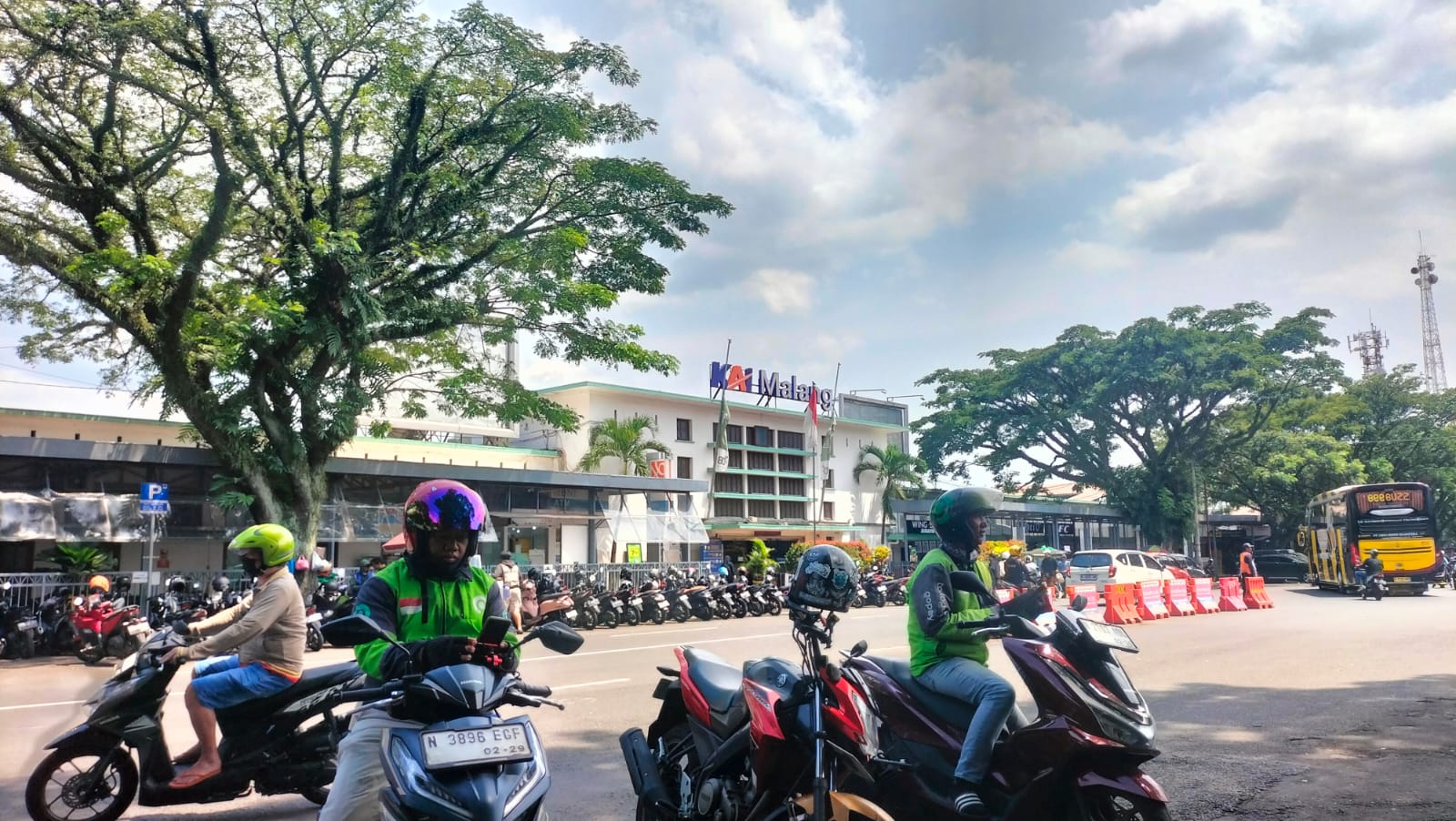 BISA JADI SAMBILAN: Dua driver ojol berhenti di area patung singa depan Stasiun Malang, Selasa (13/1). Driver ojol bisa jadi alternatif kerja part time bagi mahasiswa di Malang. (DZAKY W. MAULANA)