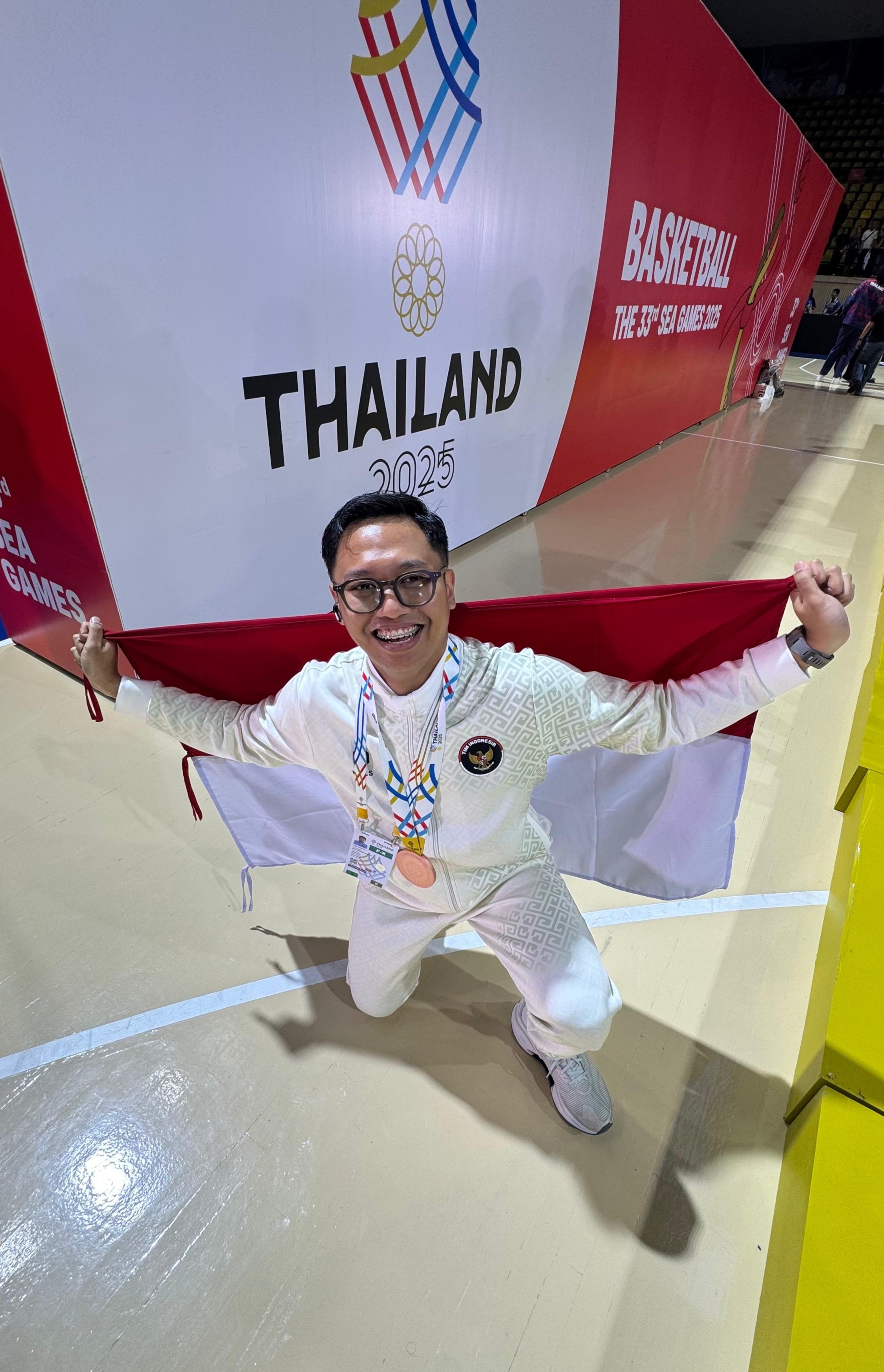 Muhammad Nanda Risdiyanto memamerkan medali perunggu SEA Games 2025 yang didapatkan Timnas Basket Putri Indonesia.