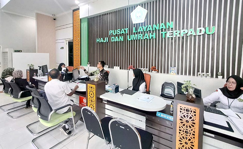 MASUK REKAP AKHIR: Petugas Kantor Kementerian Haji dan Umrah Kota Malang melayani sejumlah warga, kemarin.