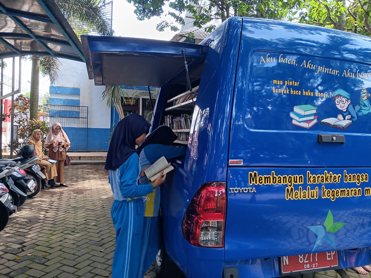 GENJOT LITERASI: Pelajar membaca buku ketika Mobil Perpustakaan Keliling (MPK) mampir di SMP N 3 Kepanjen beberapa waktu lalu.