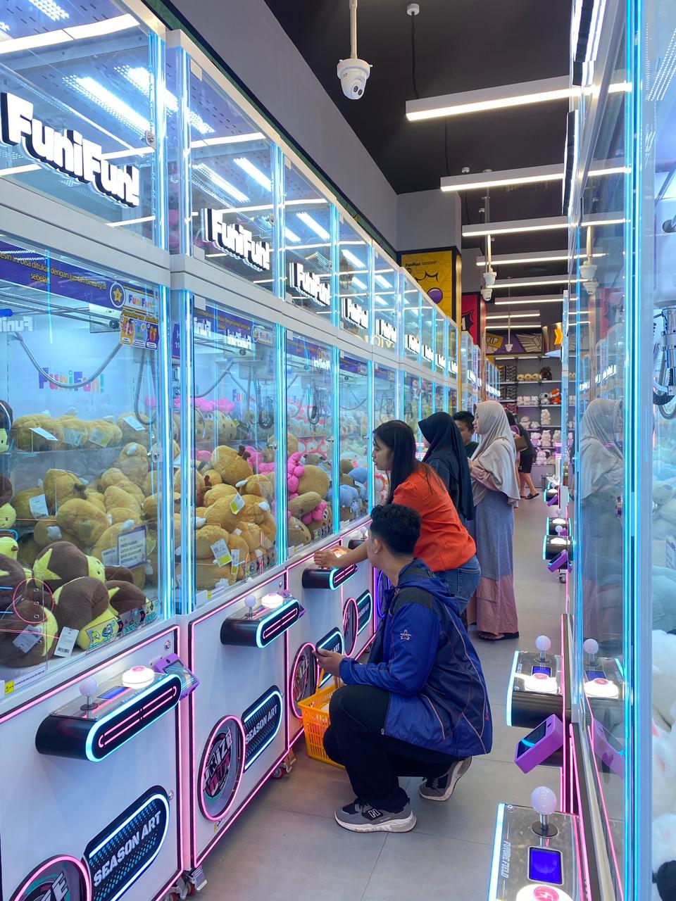 SERU DAN MENANTANG: Pengunjung Lippo Plaza Batu bermain capit mesin boneka kemarin siang. (Rori Dinanda Bestari/Radar Malang)