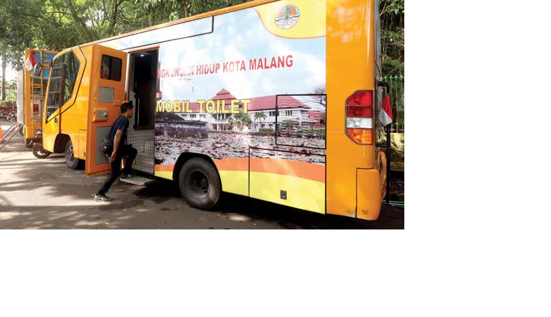 BAKAL DITAMBAH: Warga memanfaatkan toilet portabel milik DLH Kota Malang yang disiagakan di Jalan Gajahmada.