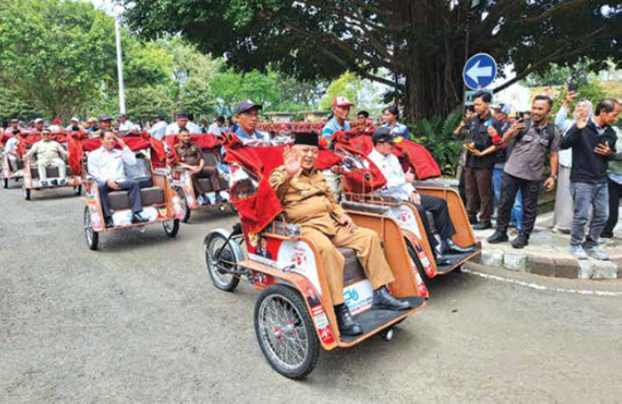 BANTUAN PRESIDEN: Bupati Malang H M. Sanusi bersama pengurus Yayasan Gerakan Solidaritas Nasional (GSN) menaiki becak listrik di kompleks Pendapa Panji Kepanjen kemarin (20/1)