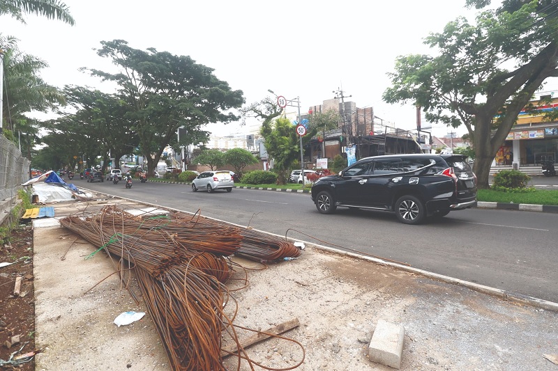 BUTUH DIPOLES LAGI: Material besi sisa proyek drainase menumpuk di trotoar Jalan Soekarno-Hatta (Soehat) kemarin siang.