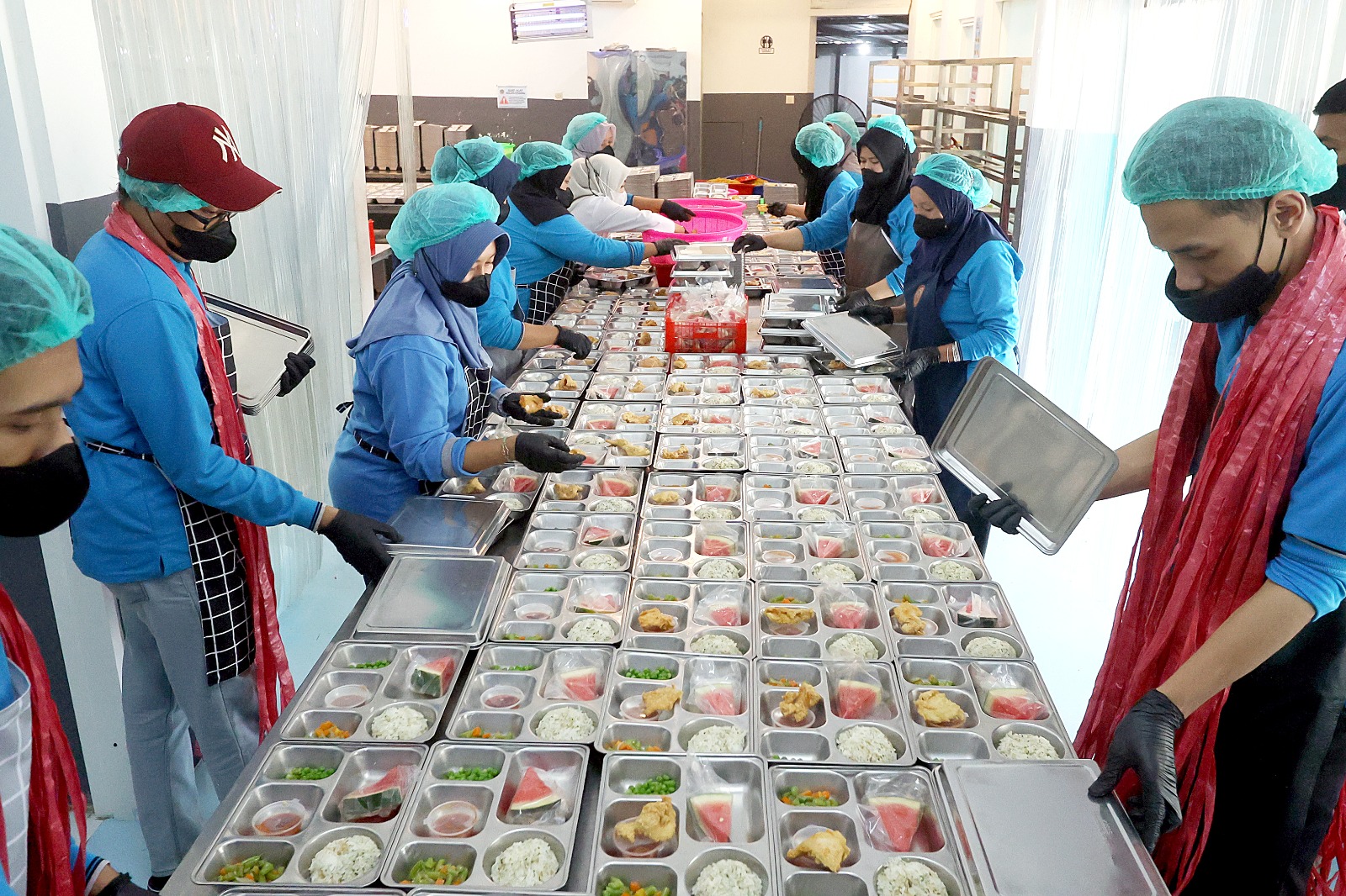 BAKAL TERCOVER BPJS: Sejumlah pekerja di SPPG Jalan Trunojoyo, Kecamatan Klojen tengah menyiapkan paket makan bergizi gratis (MBG), beberapa waktu lalu. (Darmono/Radar Malang)