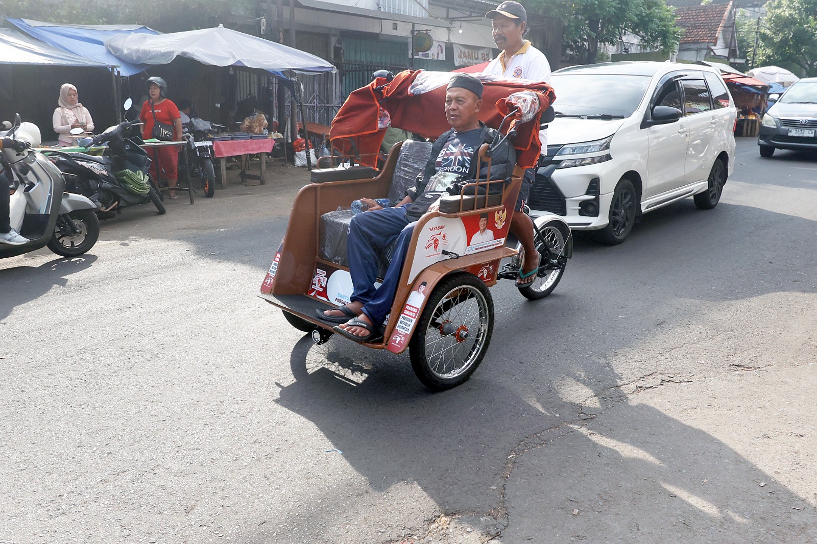 TUNGGU REGULASI: Salah satu warga memanfaatkan becak listrik di sekitar Pasar Kebalen, kemarin. (Darmono/Radar Malang)