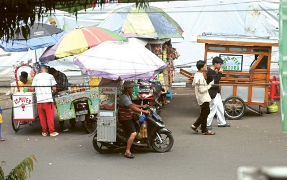 DAPAT SOROTAN: Sejumlah PKL beroperasi di dekat Alun-Alun Merdeka, kemarin. Kalangan dewan meminta pemkot agar segera menyediakan tempat khusus untuk PKL. (Darmono/ Radar Malang)