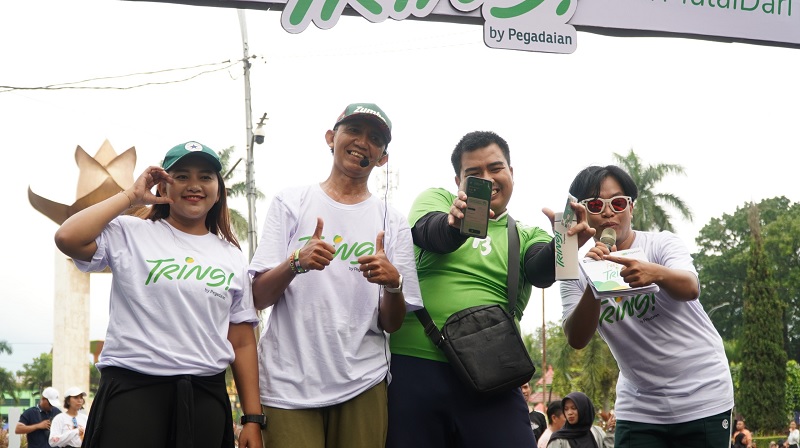 SENANG: Pengunjung CFD (baju hijau) mendapatkan doorprize BERTABUR HADIAH: Kepala Departemen Produk Gadai Pegadaian Malang setelah menunjukkan aplikasi Tring.