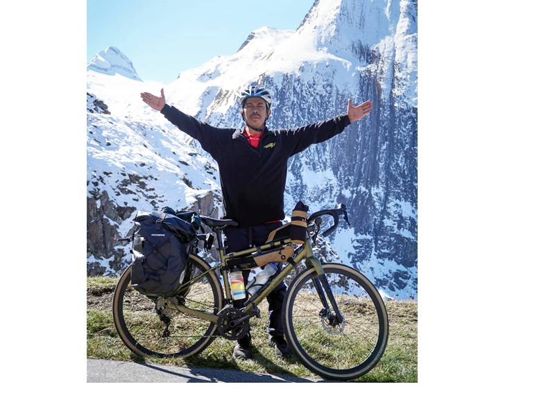 TERUS MENGAYUH: Adi Pranoto beristirahat sejenak ketika melintasi Pegunungan Alpen di Swiss, Oktober 2025 lalu. Foto kanan, Adi bertemu bintang timnas Indonesia Kevin Diks di Jerman pada 18 September