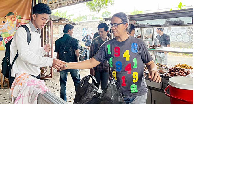 HITUNG SENDIRI: Junaedi (kanan) melayani pembeli di warungnya kemarin. Seluruh pembeli yang datang ke sana harus bisa menghitung harga pesanan sendiri.