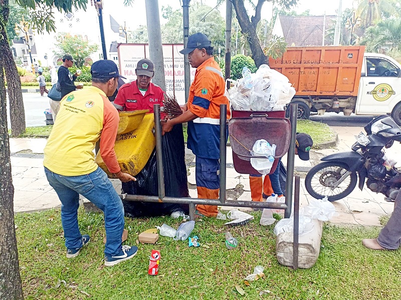 KERJA EKSTRA: Petugas DLH Kota Malang mengangkut sampah setelah event car free day (CFD) rampung, Minggu lalu (25/1).