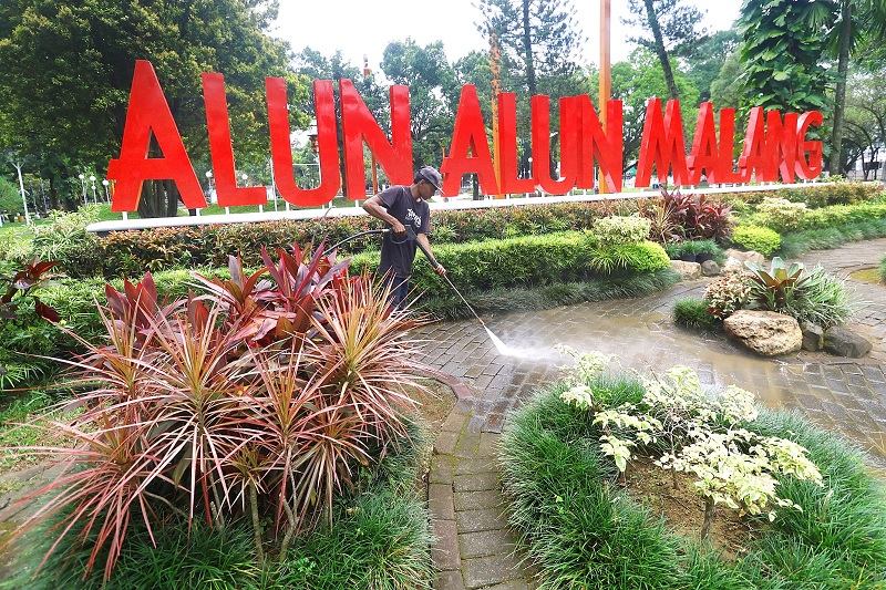 SEKALIAN UJI COBA: Pembersihan kawasan Alun-Alun Merdeka dilakukan personel DLH Kota Malang, kemarin. Wajah baru Alun-Alun Merdeka bakal dilaunching nanti malam.