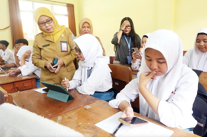 SUPPORT PENUH: Kepala Cabang Dinas Wilayah Kabupaten Malang Dwi Anggraeni (kiri) bercengkerama dengan salah satu siswi SMAN 1 Singosari, Selasa lalu (27/1).