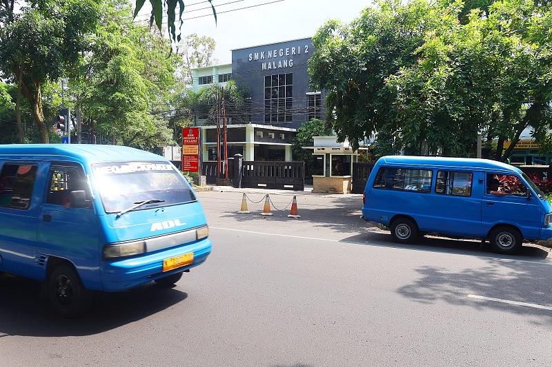 TUNGGU PERWALI: Dua angkot melintas di Jalan Veteran, kemarin. Rencana operasional angkot pelajar gratis masih tertunda untuk sementara waktu.