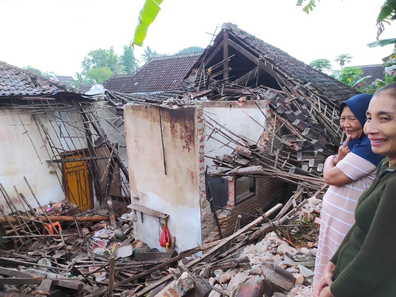 BENCANA: Warga Desa Sananrejo, Kecamatan Turen melihat rumah Saumi, 72, yang ambruk sebagian setelah diguyur hujan bercampur angin kencang.