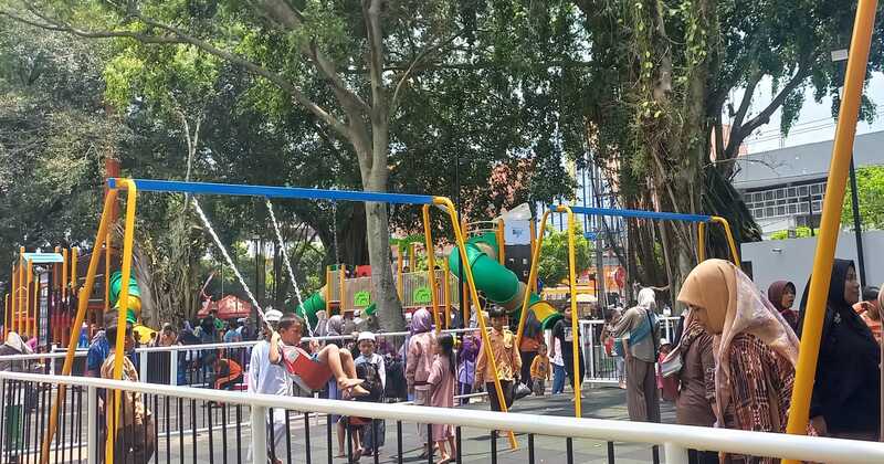 Potret keseruan anak-anak bermain ayunan di Alun-Alun Merdeka Malang pada Jumat (30/1). (Marsha Nathaniela/Radar Malang).