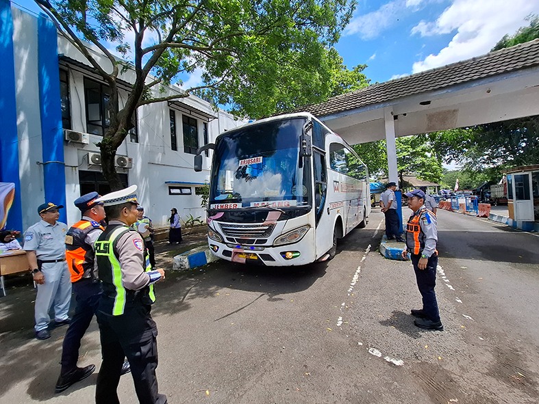 DAPATI KERUSAKAN: Petugas gabungan dari Dishub Kabupaten Malang dan Satlantas Polres Malang mengarahkan salah satu bus untuk menjalani ramcek di belakang Terminal Talangagung, kemarin siang.