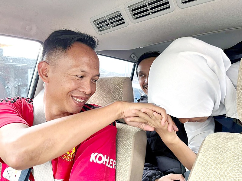 TOTALITAS: Erris Kurniawan (kiri) menyalami siswa SMPN Satap Pesanggrahan 2 Kota Batu yang dijemput kemarin. Di belakangnya, ada Frida yang ikut mendampingi.
