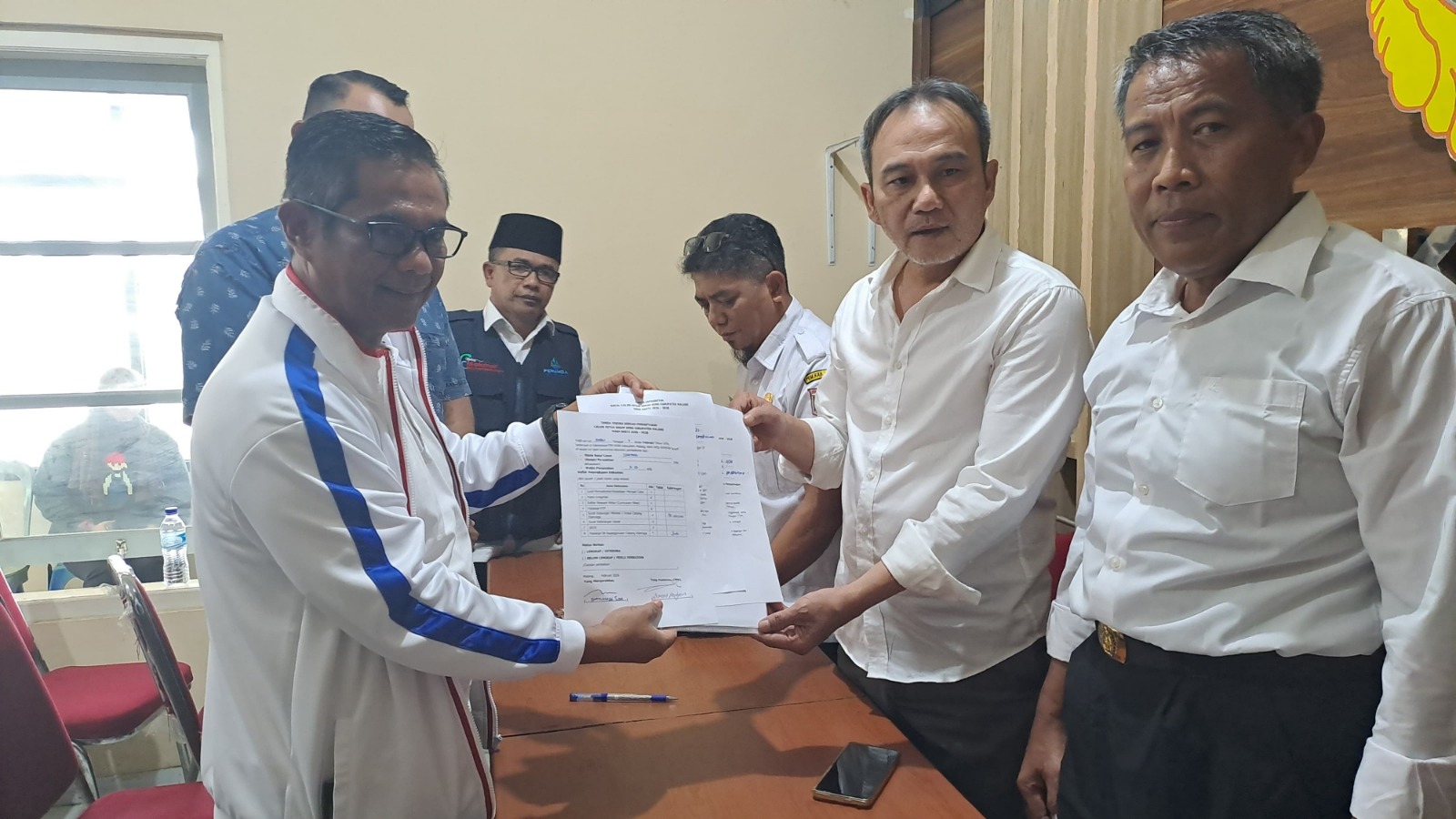 YANG PERTAMA: Ketua DPRD Kabupaten Malang Darmadi (kiri) menyerahkan berkas pendaftaran calon ketua KONI, kemarin.