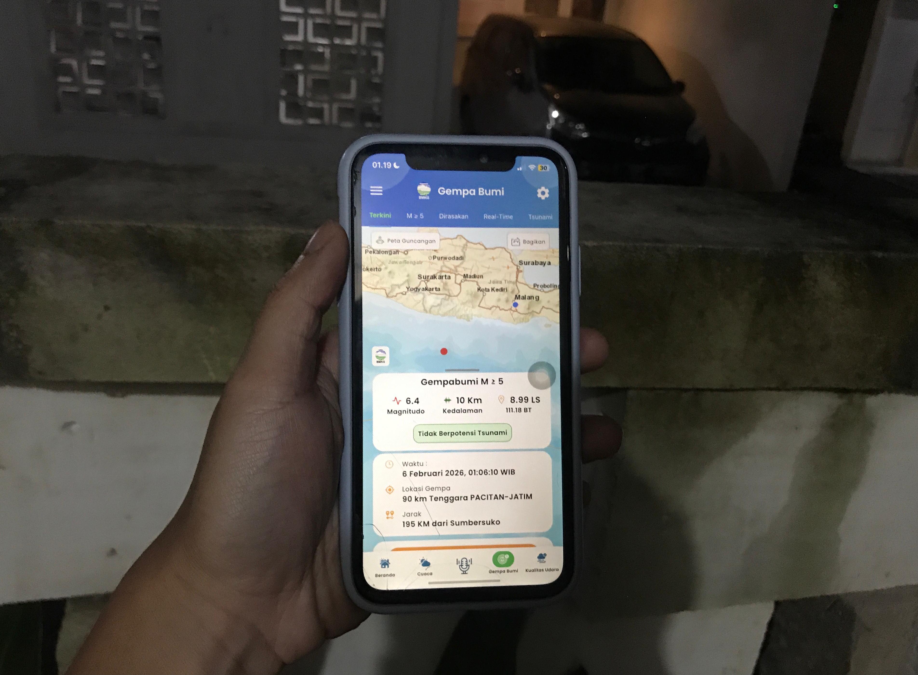 Seorang warga mengakses informasi gempa yang terjadi pada Jumat (6/2) dini hari. (Aditya Novrian/Radar Malang)