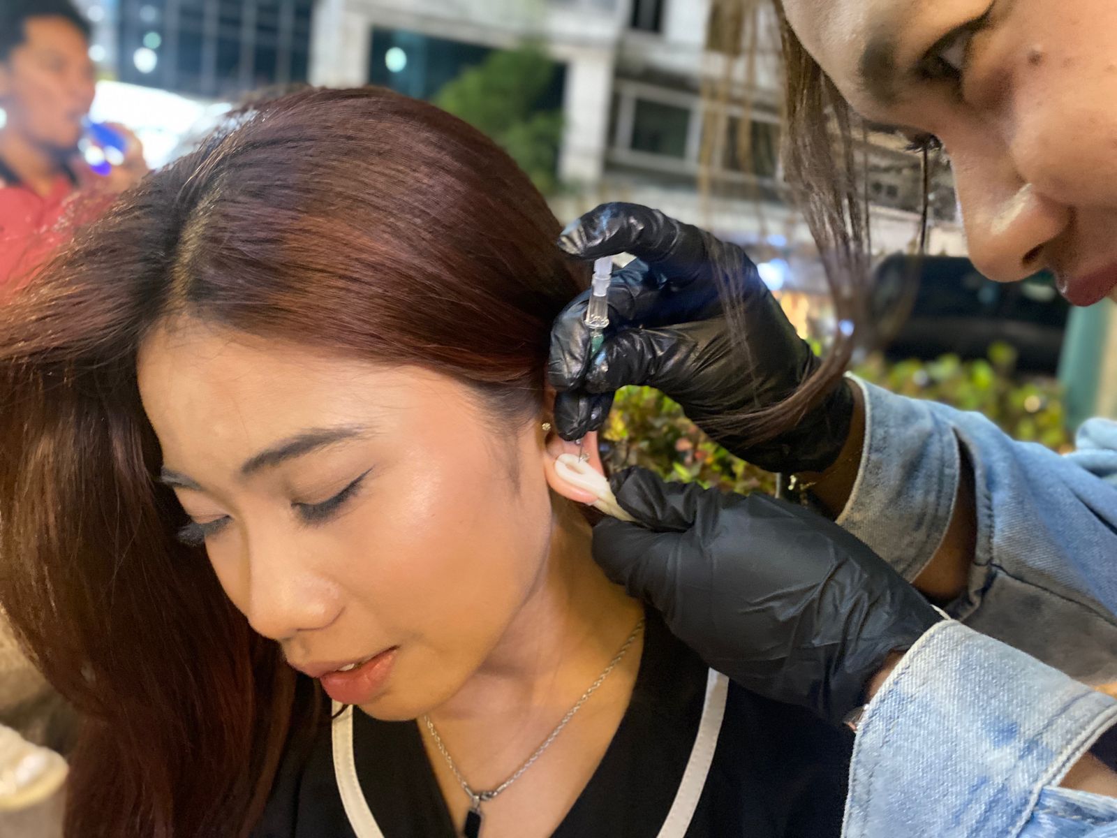TRENDY: Pengunjung Kajoetangan Heritage melakukan piercing di telinga kemarin malam. Tren tindik di bagian  tubuh kini jadi tren di kalangan anak muda. (RADAR MALANG)