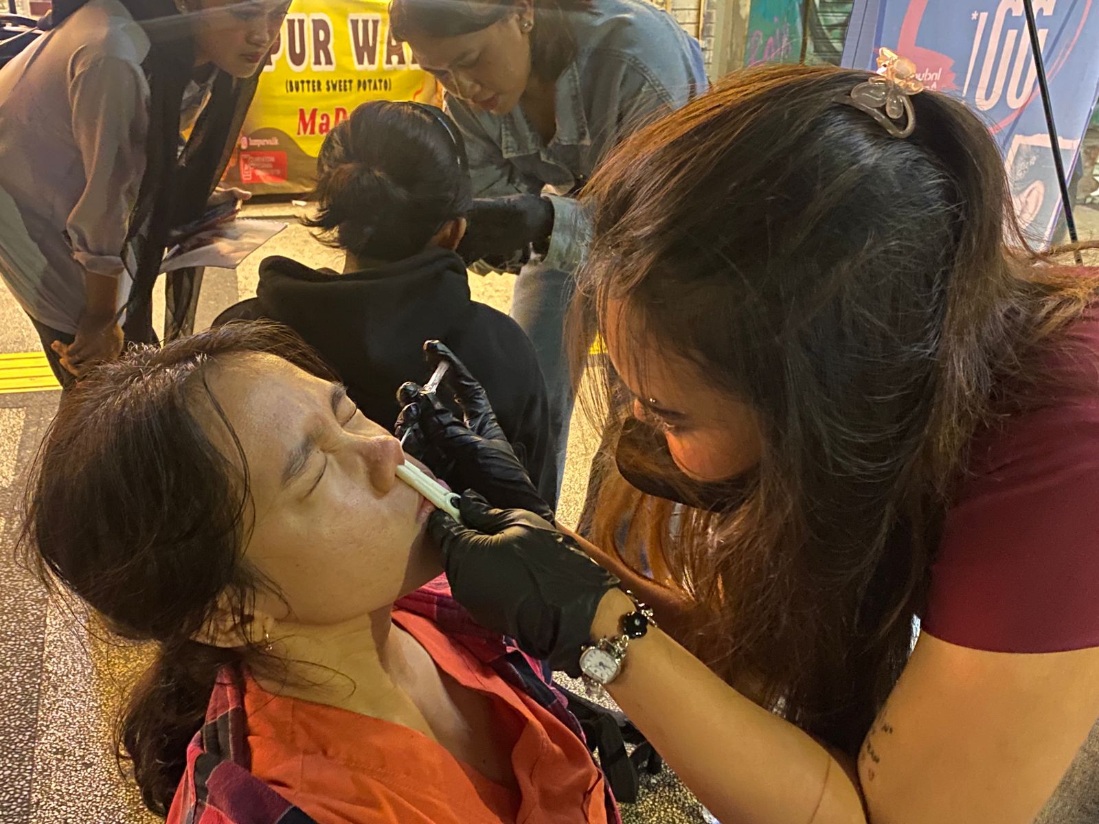TAK BIASA: Pengunjung Kajoetangan  Heritage melakukan tindik di bagian  hidung kemarin malam. (RADAR MALANG)
