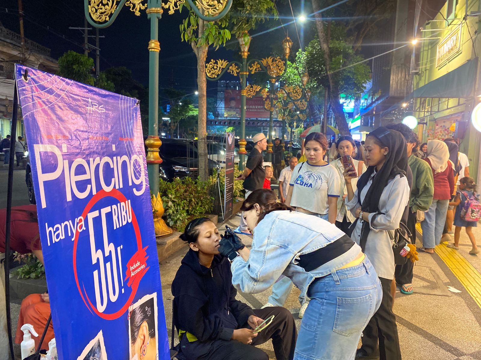 SELALU RAMAI: Lapak Ars Piercing di kawasan Kajoetangan  Heritage diserbu pengunjung yang hendak tindik kemarin malam. (RADAR MALANG)