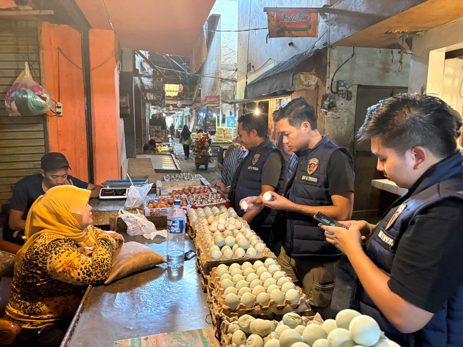 PASOKAN AMAN: Petugas Satgas Pangan Polres Malang mengecek harga dan kualitas telur DALAM inspeksi bahan pokok di Pasar Kepanjen pekan lalu. (Humas Polres Malang)