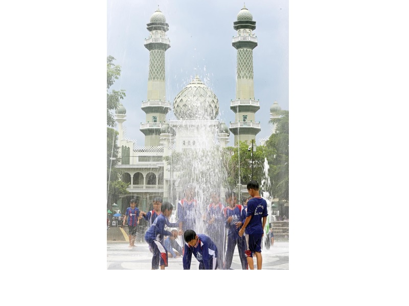 CERIA: Wisatawan anak-anak bermain air mancur di Alun-Alun Merdeka kemarin (11/2). Masyarakat mengeluhkan bau tak sedap dan sampah menyumbat saluran di area air mancur.