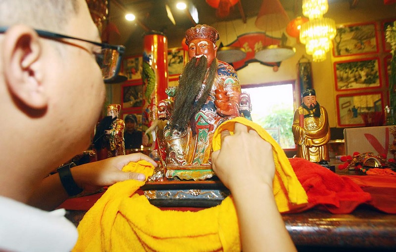 TRI DHARMA: Pengurus Kelenteng Eng An Kiong membersihkan patung dewa menjelang perayaan Hari Raya Imlek yang jatuh pada 17 Februari 2026.