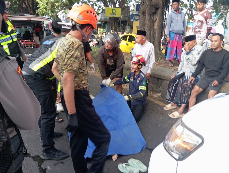 HENDA K MENYEBERANG: Evakuasi langsung dilakukan petugas terhadap korban yang baru ditabrak pengendara motor di Jalan Raya Kelurahan Pagentan, Kecamatan Singosari, kemarin pagi (11/2).