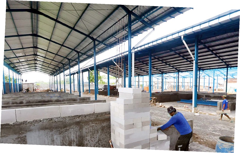 SARPRAS: Pekerja membangun lapak di tempat relokasi kemarin (12/2). Pasar penampungan sementara ini akan ditempati para pedagang PIG.