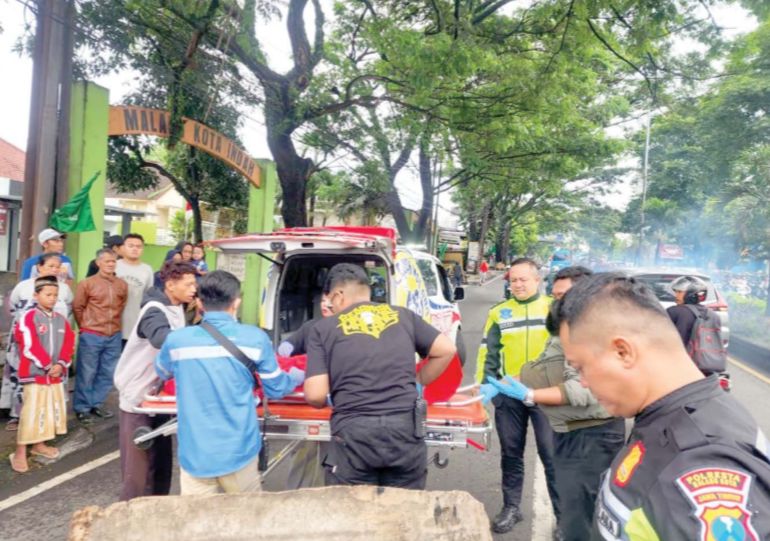 LAKA TUNGGAL: Petugas mengevakuasi korban kecelakaan tunggal yang menabrak median jalan di kawasan Balearjosari, Blimbing, Jumat pagi (13/2).