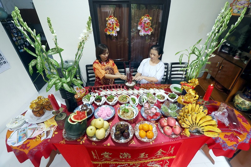 SPIRITUAL: Umat Tionghoa di Kota Malang berdoa untuk leluhurnya kemarin (16/2). Doa disertai hidangan 12 menu yang tersaji di meja.