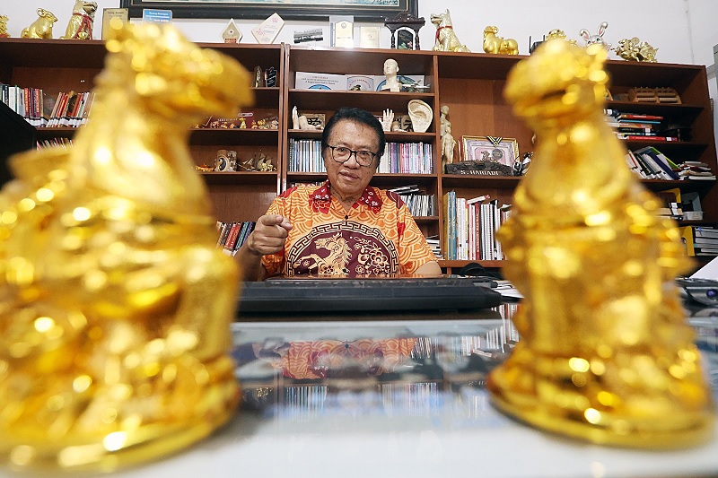 TOKOH: Pemerhati Feng Shui asal Malang, Hariadi duduk di ruang kerja yang berhias dua patung kuda api kemarin.