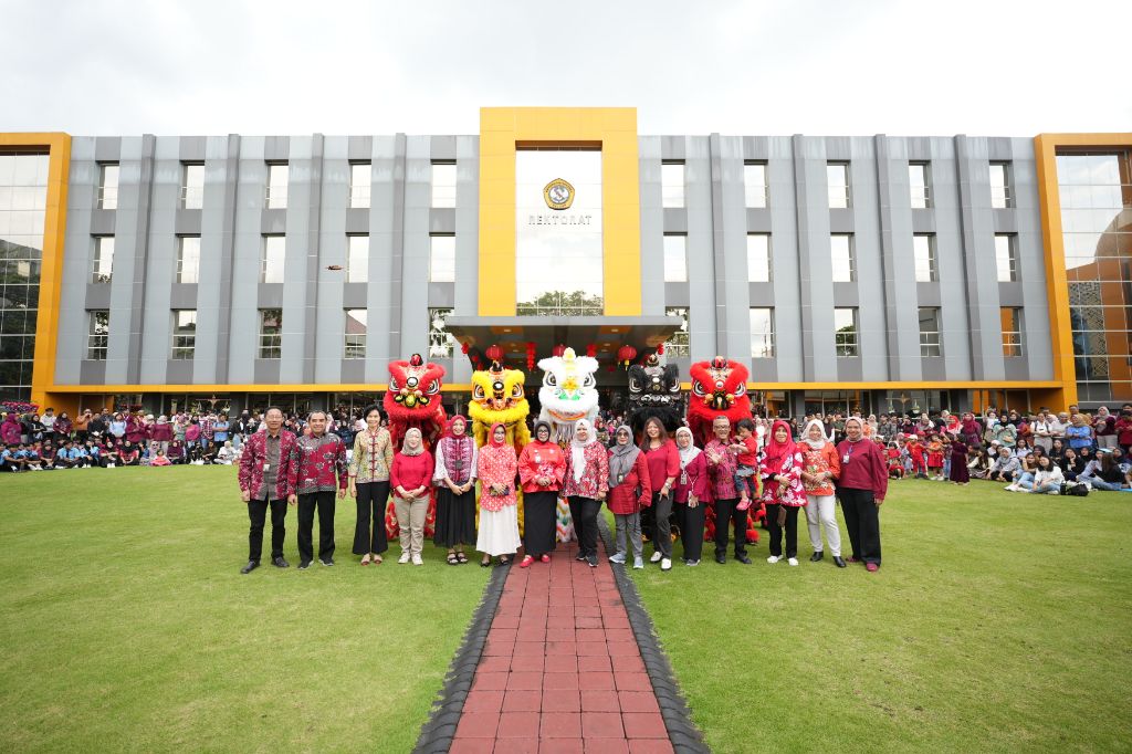 RAYAKAN KEBERAGAMAN: Sivitas Academica Universitas Merdeka Malang berfoto bersama di depan gedung rektorat setelah mendukung perayaan Tahun Baru Imlek 2577 Kongzili di lingkungan kampus, Kamis (13/2).