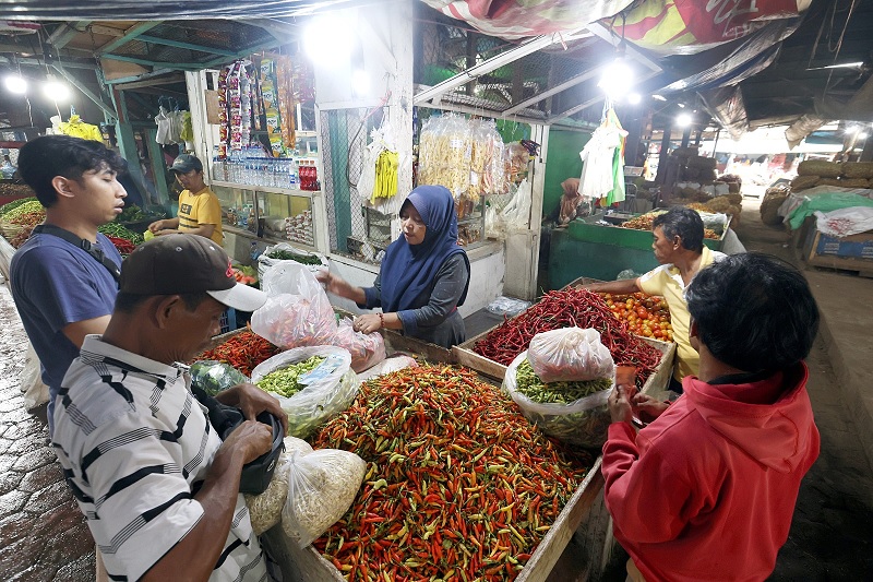 MERANGKAK NAIK: Pedagang cabai rawit di Pasar Induk Gadang (PIG) melayani pelanggannya kemarin (17/2).