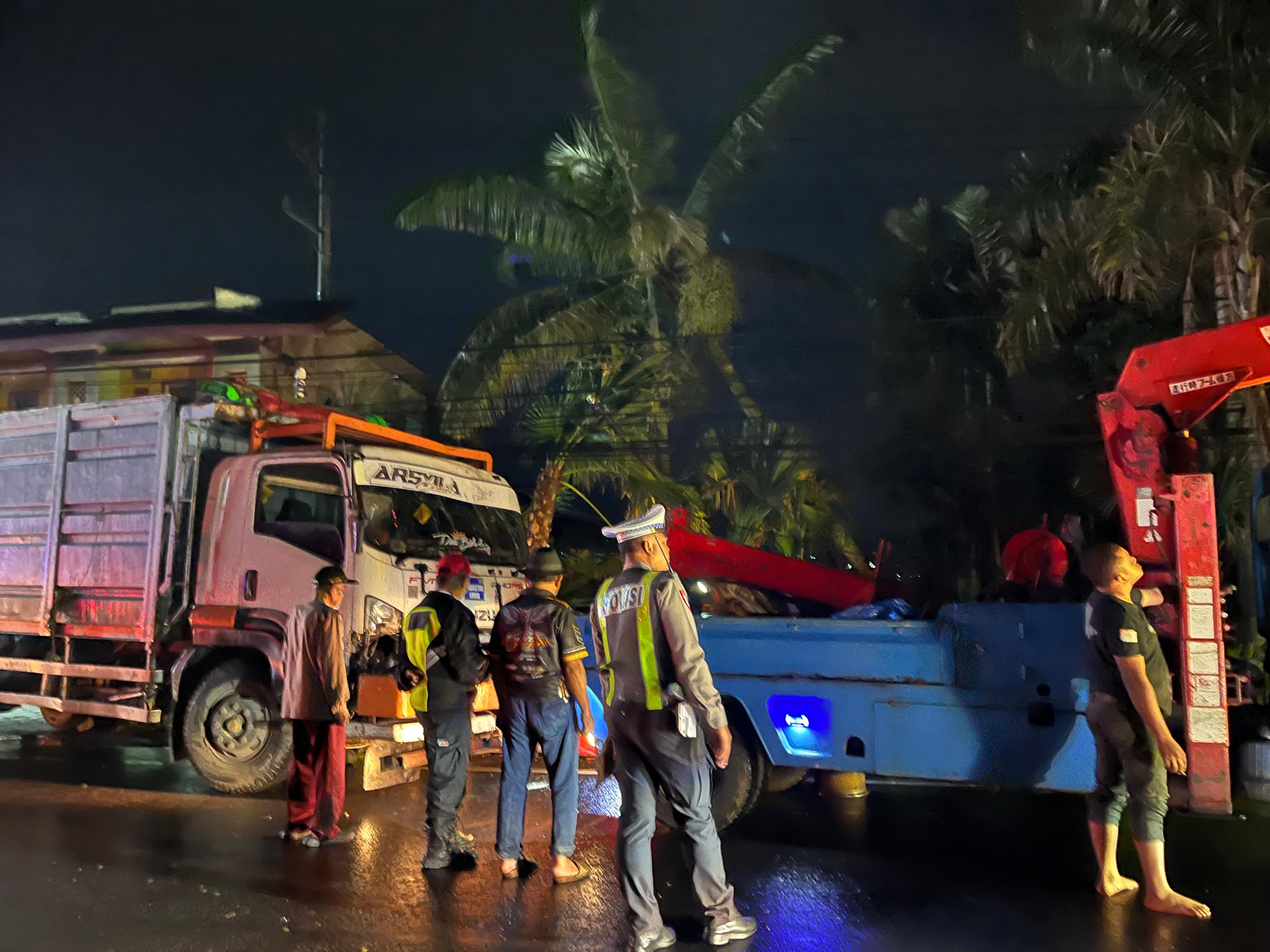 PROSES EVAKUASI: Truk fuso diderek di lokasi kejadian di Jalan Patimura, Temas, Kota Batu Rabu (18/2) malam. (Zanadia Manik Fatimah/Radar Malang)