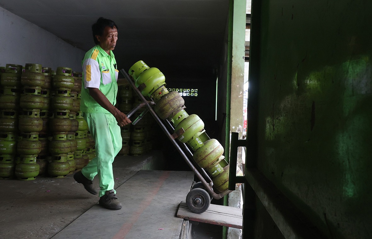 STOKNYA DITAMBAH: Salah satu pekerja di agen LPG di Kecamatan Sukun sedang menata tabung-tabung ukuran 3 kg. Agen itu rutin mengirim pasokan ke Kecamatan Turen dan Sumbermanjing Wetan.