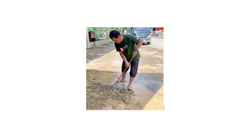 BANTU SESAMA: Budi Sasmitro membersihkan lumpur bekas banjir di Kabupaten Aceh Tamiang.