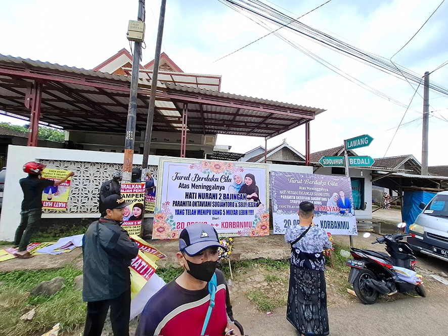 Karangan bunga dan banner berisi foto terduga pelaku penipuan jual beli popok dipasang di salah satu rumah di Dusun Krajan, Desa Srigading, Kecamatan Lawang, kemarin siang.&nbsp;(Biyan Mudzaky Hanindito)
