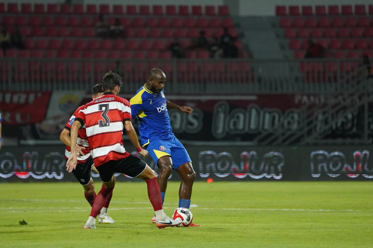 Striker Arema FC Joel Vinicius mencoba melewati hadangan pemain Madura United dalam laga BRI Super League, Sabtu (21/2) malam. (MO Arema FC)